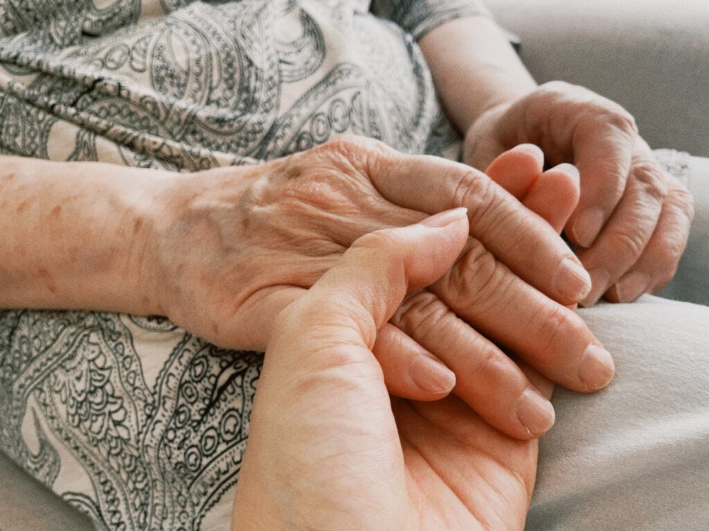 高齢者の手を握る